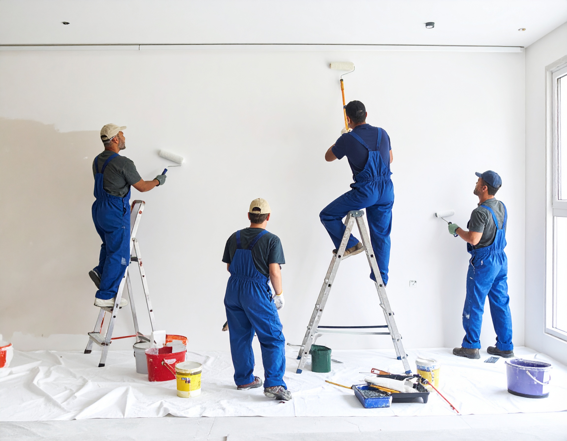 Des ouvriers en train de faire des travaux de peinture intérieure dans une maison
